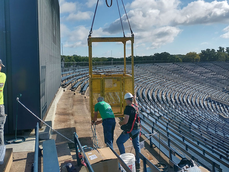 Technician troubleshooting scoreboard wiring